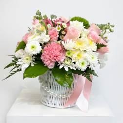 Pink and white mixed bouquet in a white basket with a pink ribbon
