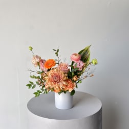 Peach and pink mixed bouquet in a white vase