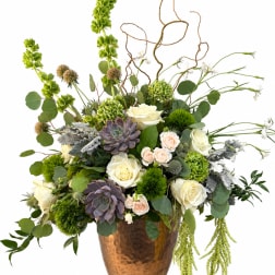 Mixed floral arrangement with white roses and green succulents in a copper vase
