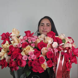 Large arrangement of red, pink, and cream roses in a black hat box