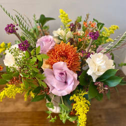 Mixed bouquet with lavender roses, orange chrysanthemum, and white carnations in a vase