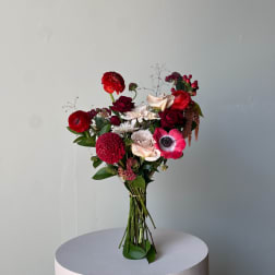 Bouquet of red, pink, and white flowers on a round pedestal
