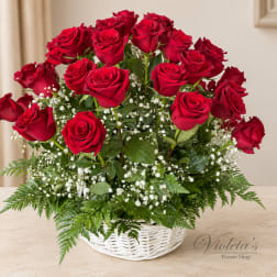Red roses arranged in a white basket with baby's breath