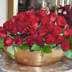 Red roses arranged in a low gold bowl