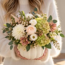 Mixed bouquet in a white pumpkin vase with cream, blush, and green blooms
