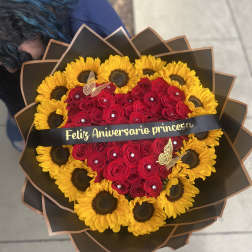 Heart-shaped bouquet of red roses and yellow sunflowers with a ribbon