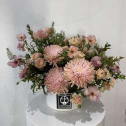 Pink chrysanthemum bouquet in a white hat box
