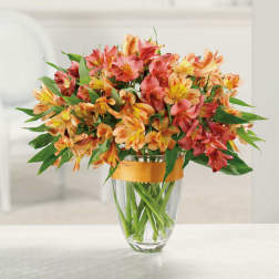 Bouquet of orange and pink flowers in a clear glass vase