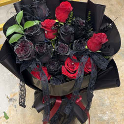 Bouquet of red and black roses wrapped in black paper with lace ribbons