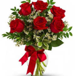 Bouquet of red roses with greenery in a clear glass vase