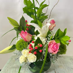 Pink and white roses with lilies in a glass vase