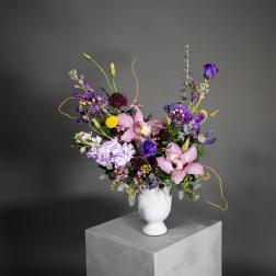 Mixed bouquet of pink and purple flowers in a white vase