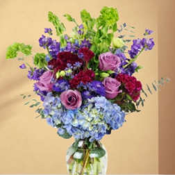 Bouquet of purple and blue flowers in a clear glass vase