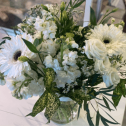 White mixed bouquet with gerbera daisies and roses in a clear vase