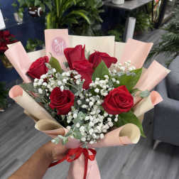 Bouquet of red roses with baby's breath in pink wrapping