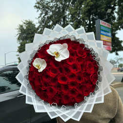 Large round bouquet of red roses with two white orchids
