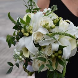 White rose and calla lily bouquet with green berries and foliage