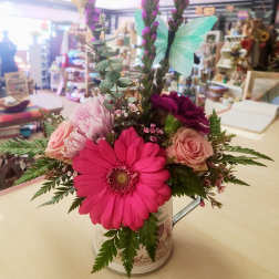 Mixed bouquet in a decorative tin with pink and purple flowers and butterfly picks
