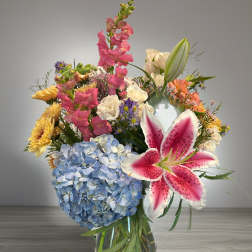 Mixed bouquet in a glass vase with blue hydrangea and pink lily