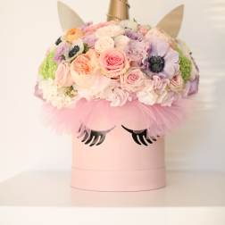 Pastel flower arrangement in a pink unicorn box with a gold horn