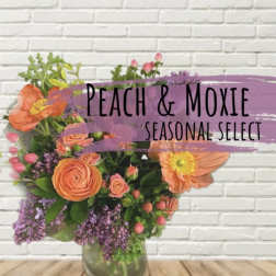 Peach and purple mixed flower arrangement in a glass vase