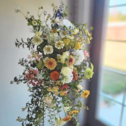 Loose bouquet of mixed wildflowers in white, yellow, orange, pink, and blue