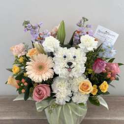 Flower arrangement shaped like a white teddy bear with roses and daisies