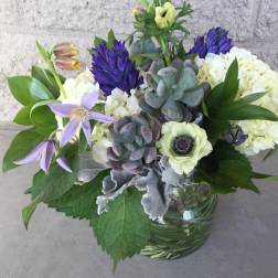 Mixed bouquet with purple and white flowers in a glass vase