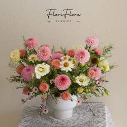 Pink and white mixed flower arrangement in a white vase