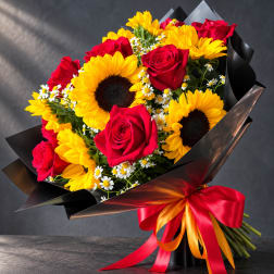 Bouquet of red roses and yellow sunflowers wrapped in black paper with a red ribbon