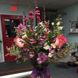 Tall mixed bouquet in a glass vase with pink and purple flowers