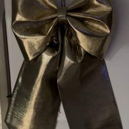 Large metallic gold bow on a white surface