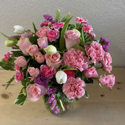 Pink roses and carnations arranged in a glass vase