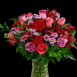 Bouquet of pink and red roses with carnations in a glass vase