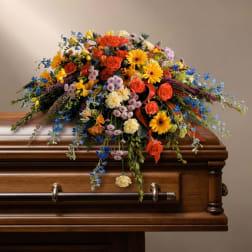 Colorful floral spray arranged on a wooden casket