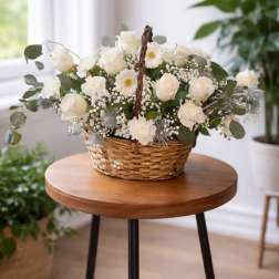 White roses and daisies arranged in a wicker basket
