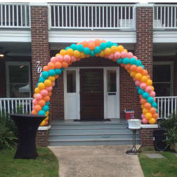 Colorful balloon arch framing a house entrance