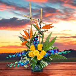Tropical flower arrangement with yellow roses and orange bird-of-paradise in a vase