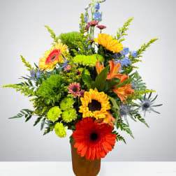 Colorful mixed flower arrangement in a brown vase