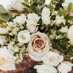 Arrangement of blush roses and white blooms in a soft neutral palette