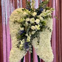 Large white floral standing spray on an easel with blue accents