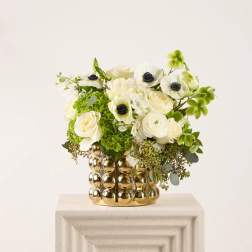 White and green floral arrangement in a gold textured vase