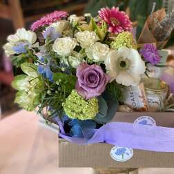 Mixed bouquet with roses, anemones, and daisies in a gift box