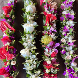 Set of four colorful floral garlands with red, white, pink, and purple blooms on a wooden surface