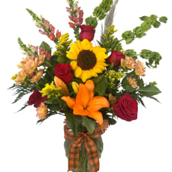 Sunflower and red rose bouquet in a glass vase with an orange ribbon