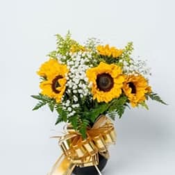 Sunflower bouquet with white filler flowers and a gold ribbon bow