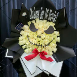 Bouquet of cream roses wrapped in black paper with a red bow and face cutout