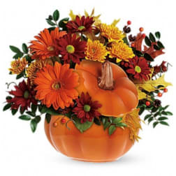 Orange pumpkin arrangement with red and yellow flowers