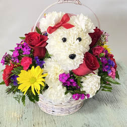 Flower basket with a white teddy bear face, red roses, and bright mixed blooms