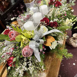 Holiday centerpiece with candles, red roses, and pink protea